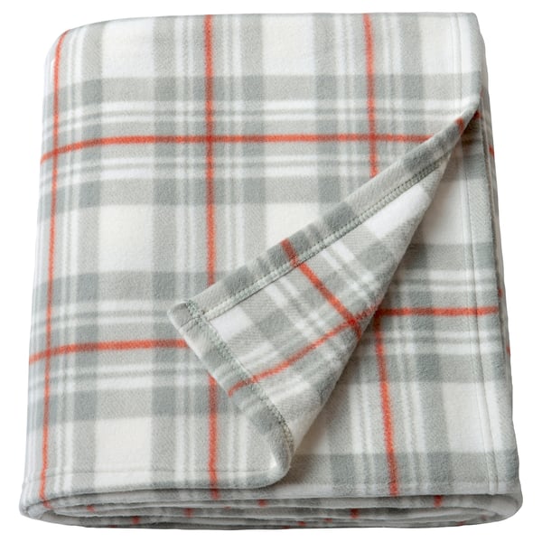A grey and orange chequered blanket folded neatly. Its made of 100% recycled polyester, lightweight, and perfect for cosy moments.