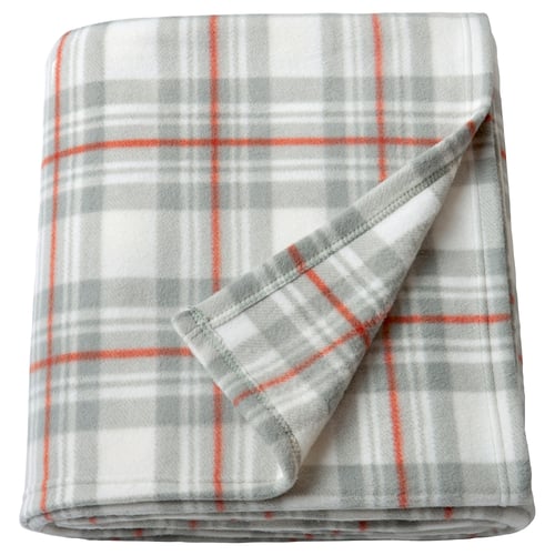 A grey and orange chequered blanket folded neatly. Its made of 100% recycled polyester, lightweight, and perfect for cosy moments.