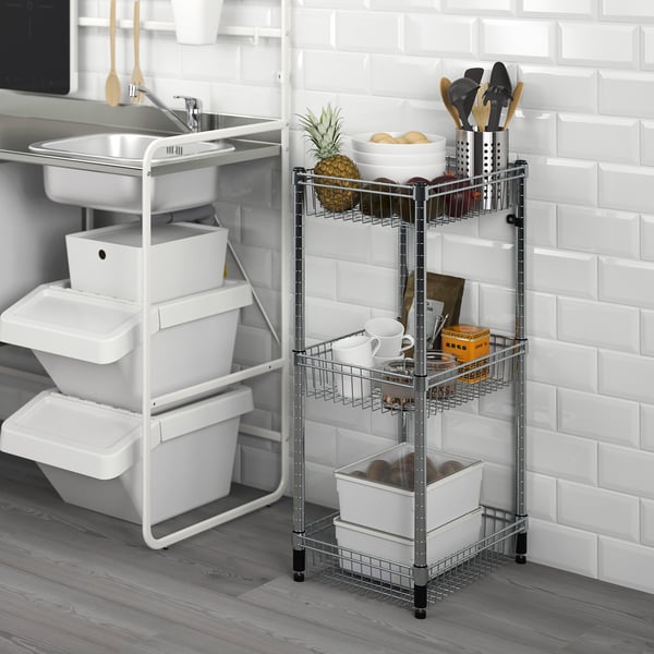 Silver OMAR 3-tier storage rack with kitchen items, next to white sink and stacked storage bins.