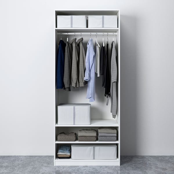 White PAX wardrobe, organised with clothes on hangers, folded clothes, and storage boxes.