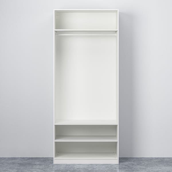 White open PAX wardrobe with adjustable feet and shelves, designed for compact spaces.
