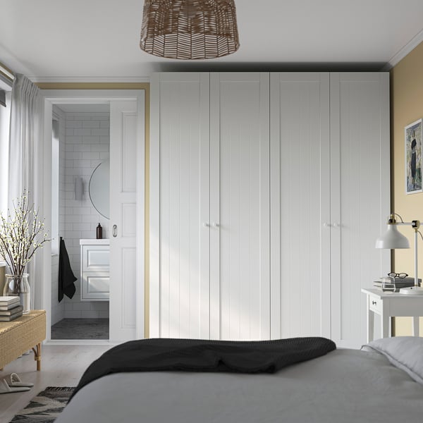 Modern bedroom with large PAX wardrobe, bed, bedside table, and pendant light.
