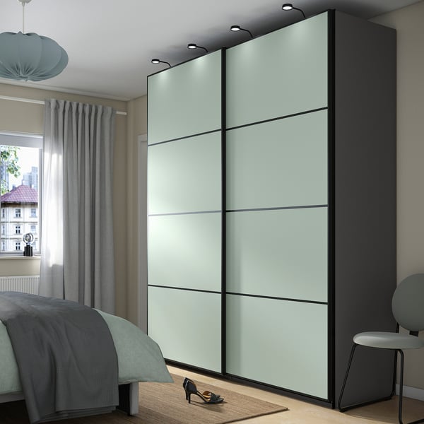 Modern bedroom with large PAX wardrobe, blue curtains, bed, and grey stool.