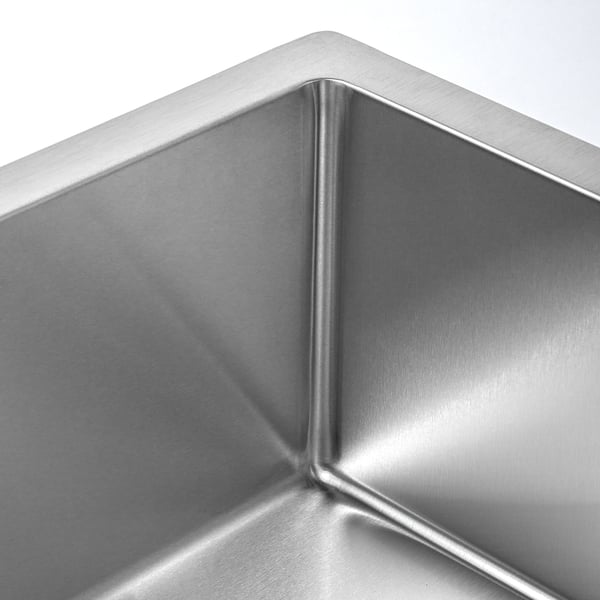 Stainless steel sink with sleek, small radius corners, reflecting light, showcasing its durable and polished surface.