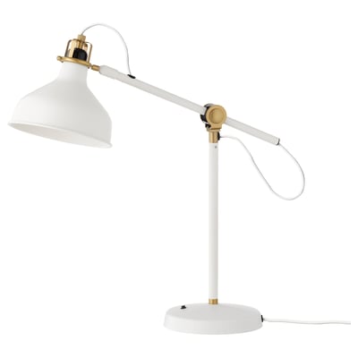 A white, adjustable RANARP desk lamp with golden metal accents. It has a round base, a long arm, and a movable shade for directed light.