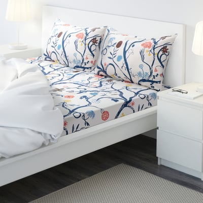 Ikea REVFINGERÖRT: blue floral bedding on queen bed with white bed frame and nightstands.