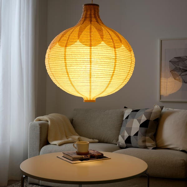 RISBYN lamp with rice paper and birch detail casts warm light in living room.