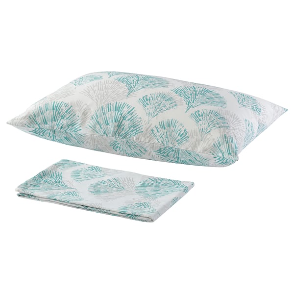 Two turquoise and white floral pillows with a fan-like pattern lay flat, one folded.