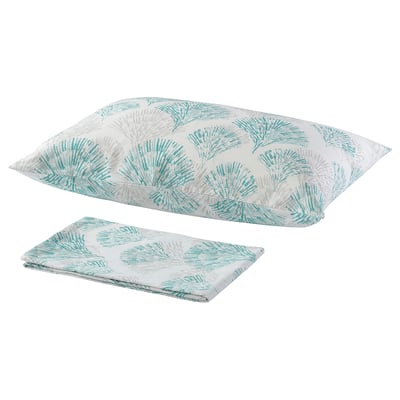 Two turquoise and white floral pillows with a fan-like pattern lay flat, one folded.