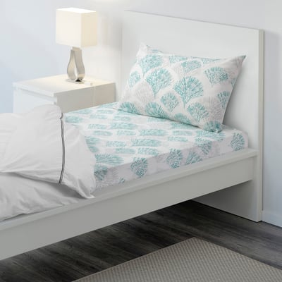 Blue leaf RÖDFIBBLA cotton bed set on white frame, neat minimalist bedroom.