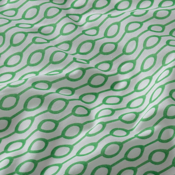 Green and white patterned bedspread, crisp and neatly folded, showcasing a modern design and quality fabric.