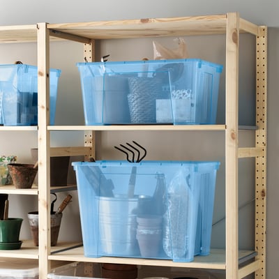 Blue SAMLA boxes on wooden shelf, holding varied items visibly.