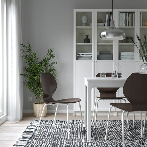 Dark brown veneer SIGTRYGG stackable chairs around white dining table.