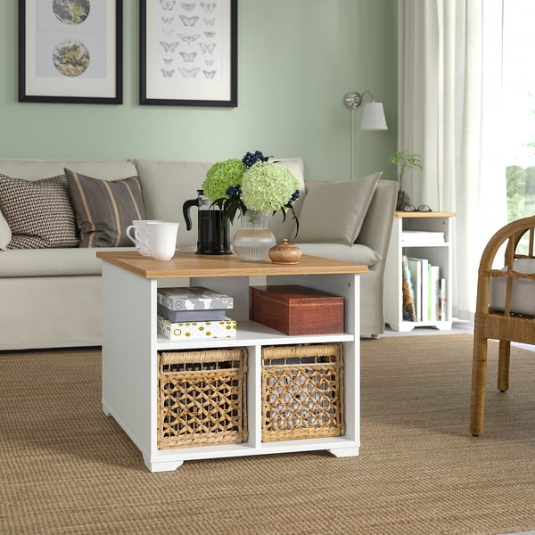 Modern living room with SKRUVBY coffee table in white & oak, baskets, decor, beige sofa, green wall, art.