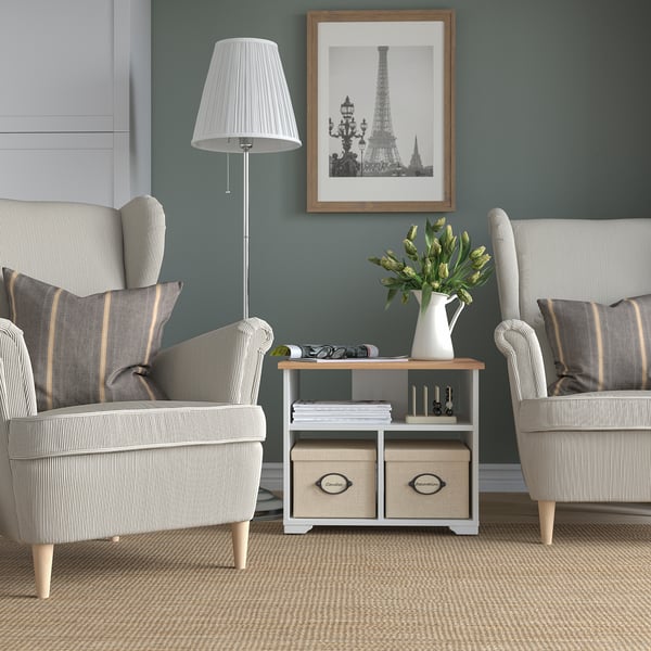 Cosy living room with SKRUVBY coffee table, striped armchairs, lamp, and eiffel tower picture, holding vase with greenery and magazines.