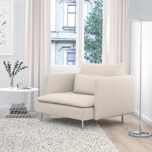 Off-white SÖDERHAMN armchair with plush cushions and metal base near a large window with curtains. Bright, serene room with side table and plants.