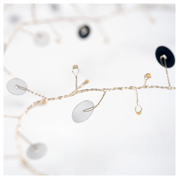 Elegant string lights with silver discs and warm glow, perfect for festive decor.
