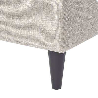 Grey upholstered ottoman with tapered black legs.