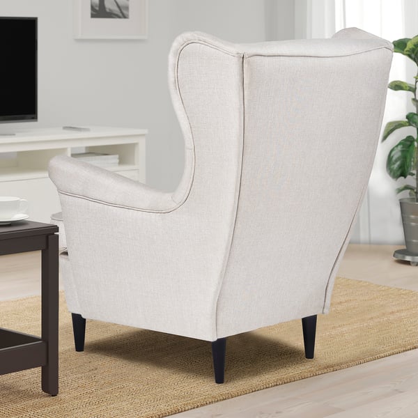 Image shows a light grey, upholstered wingback chair with black legs, designed for comfort and support.