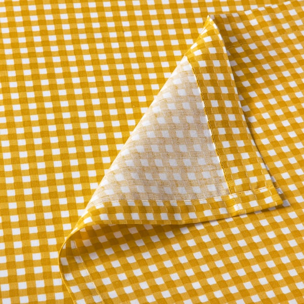 Close-up of a neatly folded yellow and white chequered bedsheet, showcasing its soft texture and precise stitching.