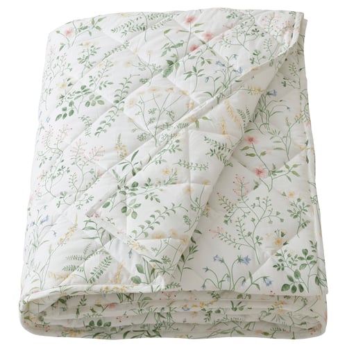 White floral quilted comforter with green leaves and pink, yellow, and blue flowers.