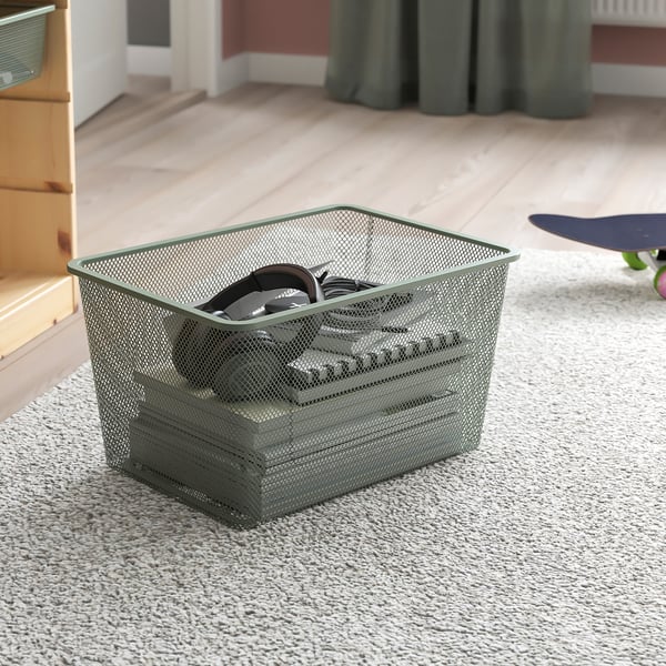 Mesh storage basket on carpet, holding headphones and cables, part of TROFAST series.