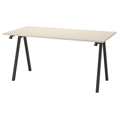 A TROTTEN desk with light beige top and black metal legs, featuring a slim and modern design for efficient space usage.