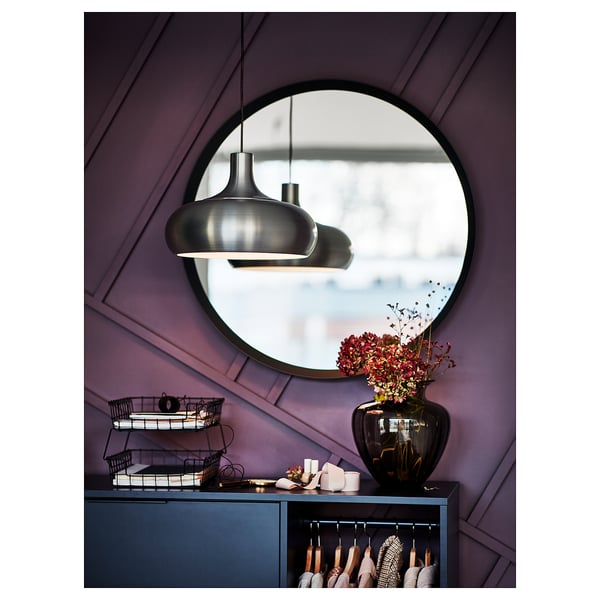 Mirror on purple wall, blue cabinet with flowers, grey pendant lamp.