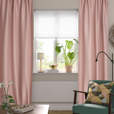 Room with pink curtains, green plant, teal chair, yellow pillow.