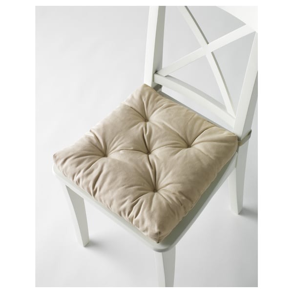A white chair with a beige, cushioned seat pad secured by fasteners.