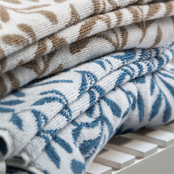 Stacked folded towels, blue and white patterns, cotton.