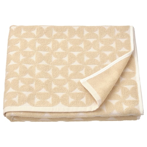 Light beige towel with geometric pattern, soft cotton blend, folded neatly.