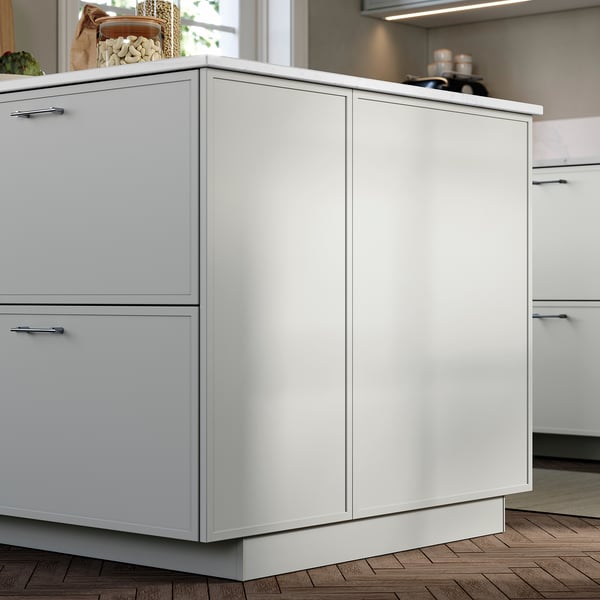 ASPUDDEN light grey panel covers kitchen base cabinet sides with thin frame.