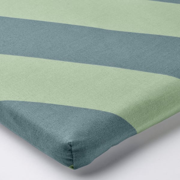 Corner of striped green and blue cushion, smooth texture, clean design.