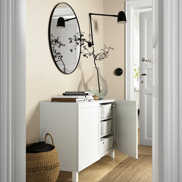 Modern hallway with BESTÅ sideboard, mirror, lamps, and vase.