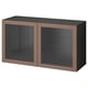 Modern BESTÅ storage unit in brown with sleek glass doors and shelves.