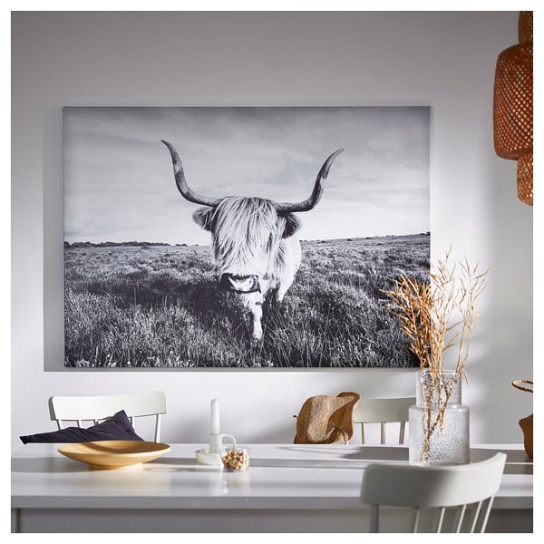 Bull painting above dining table with decor.