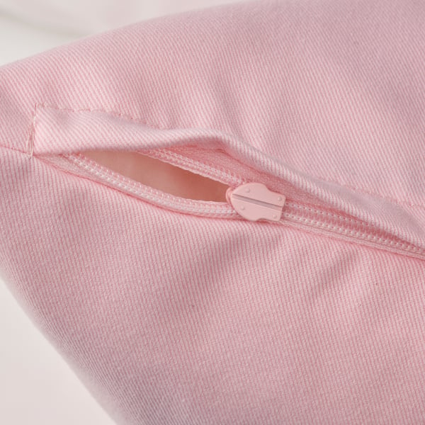 Close-up of pink zip on recycled fabric pillow, highlighting product quality.