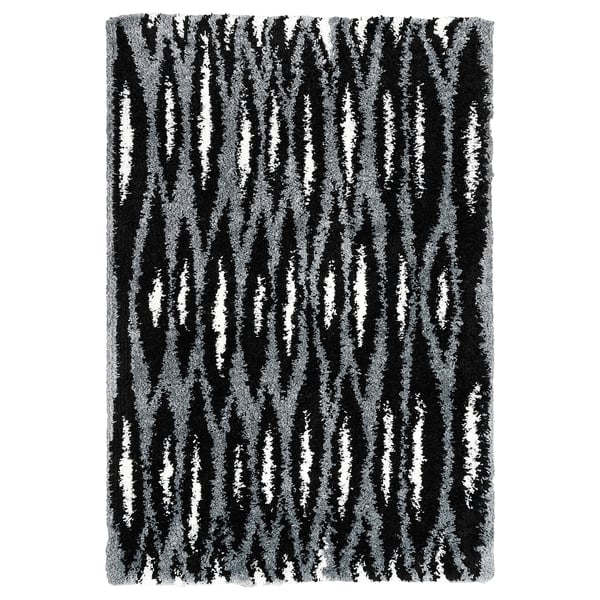 Black and white striped rectangular rug with a shaggy texture. Part of the nytillverkad collection, it a modern design with diagonal patterns.