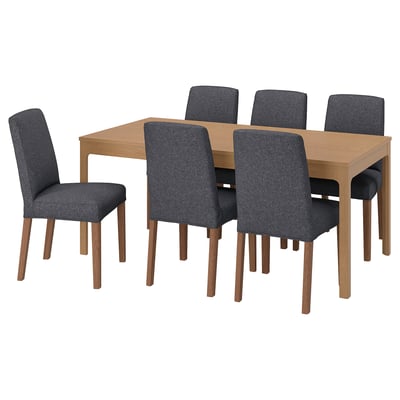 A grey, extendable dining set. It includes a light wood table and six matching chairs.
