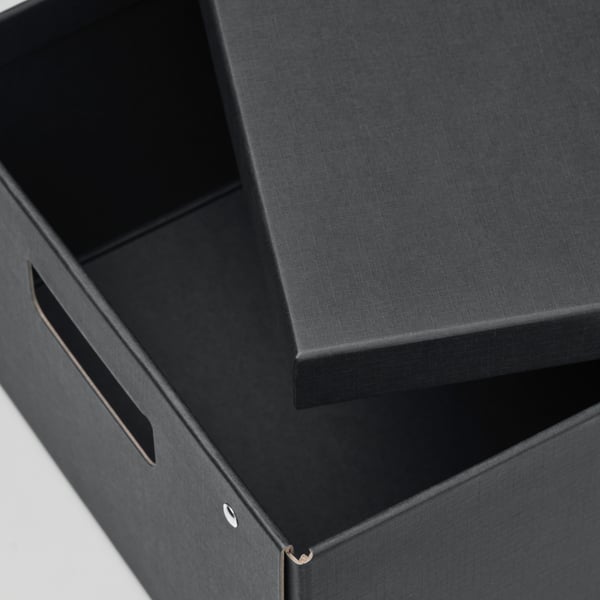 Black storage box with cut-out handles, sturdy construction, perfect for organising papers and desk accessories.