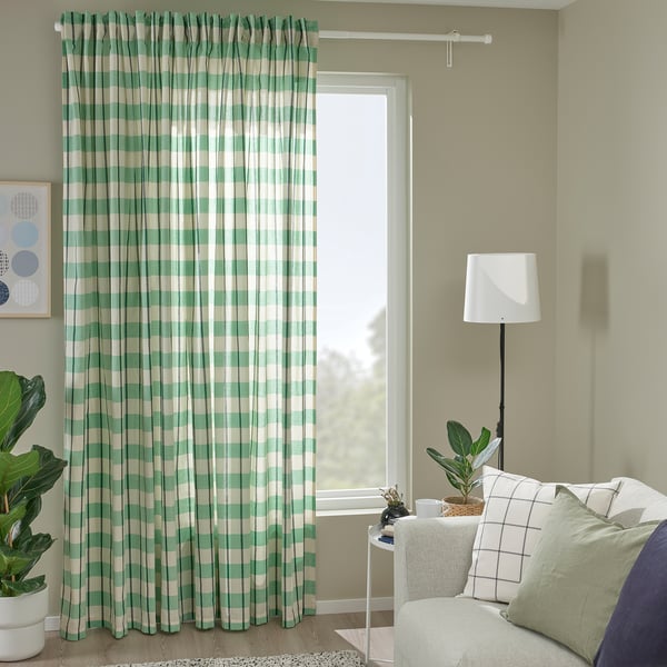 Cosy room with GLANSHAGTORN curtains, large window, plant, lamp, and armchair with green pillows.