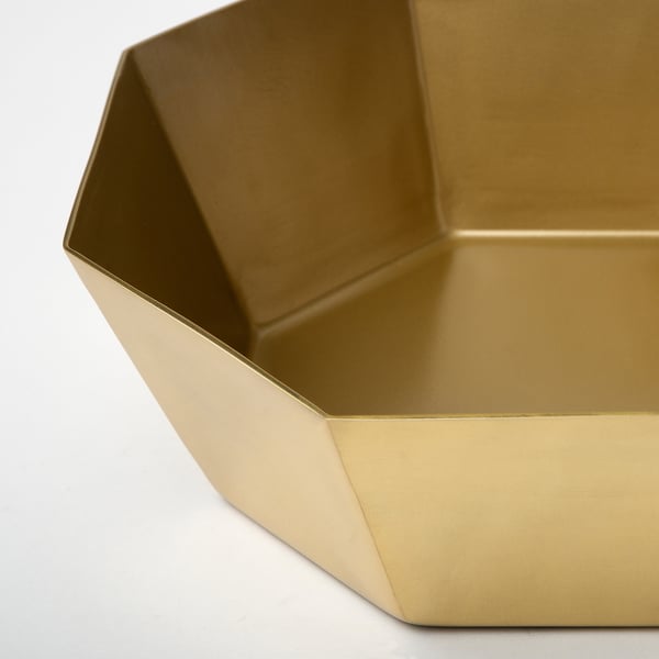 Gold octagonal serving bowl, sleek & shiny surface, sits on table.