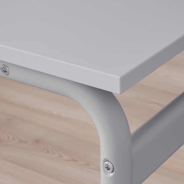 Close-up of modern tables sleek, white top and sturdy metal leg, showcasing quality design.