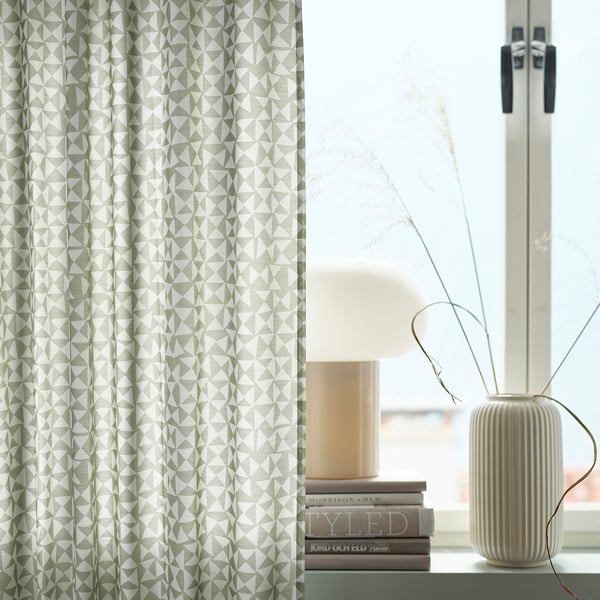 Modern room with HÅRKÖRVEL green-white geometric curtains, stylish window sill, lamp, books, and minimalist decor.