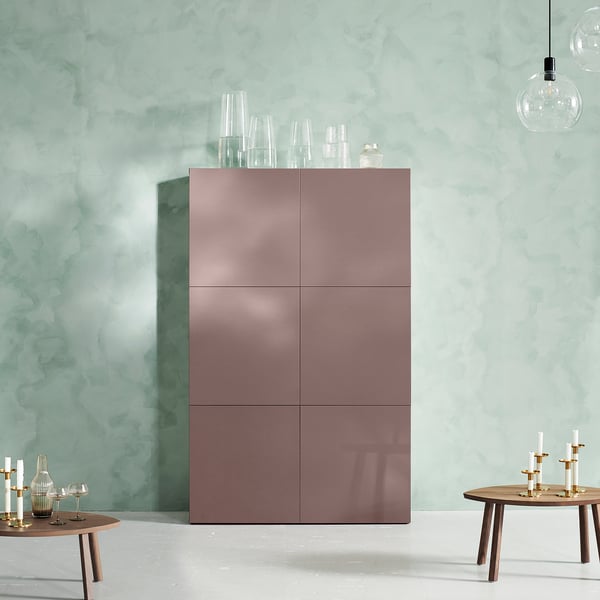 Modern room with rose gold cabinet, two round wooden tables with candles.