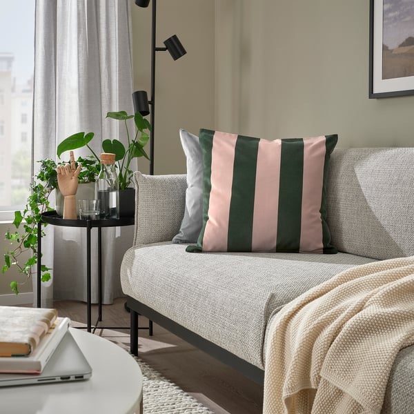 Living room with light sofa, IDGRAN pillow, plant, vase, laptop, bright, minimalist.
