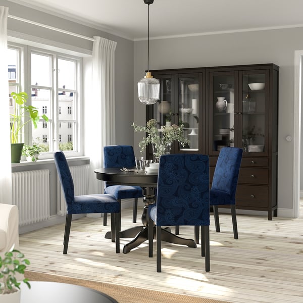 Dining area with INGATORP table, blue upholstered chairs, wooden floor, large window, and dark cabinet.