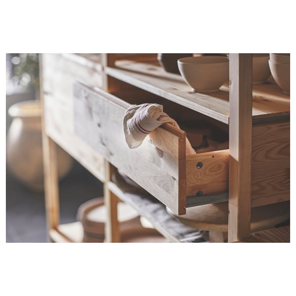 IVAR wooden cabinet with open light-colored drawer displaying bowls.