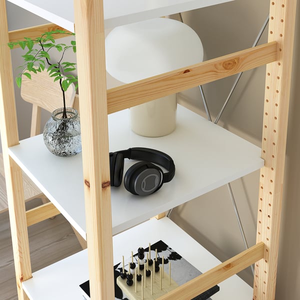 Wooden IVAR shelf with lamp, headphones, plant, and chess board.